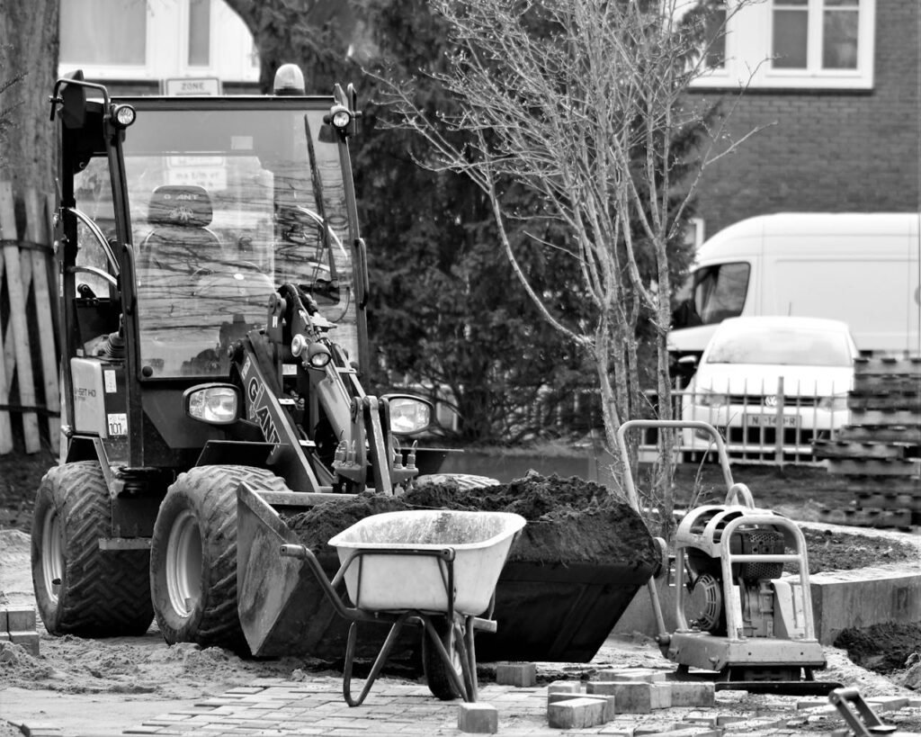 pexels photo 9465378 A black and white image showing construction machinery and tools operating outdoors.